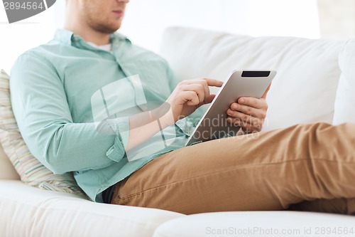 Image of close up of man with tablet pc computer at home