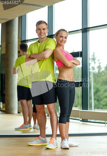 Image of smiling man and woman in gym