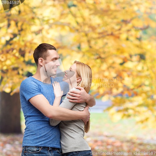 Image of smiling couple hugging and looking at each other