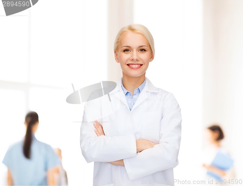 Image of smiling female doctor with group of medics