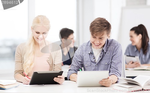 Image of two smiling students with tablet pc at school