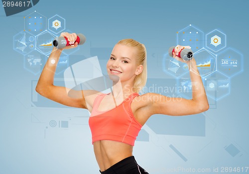 Image of smiling beautiful sporty woman with dumbbells