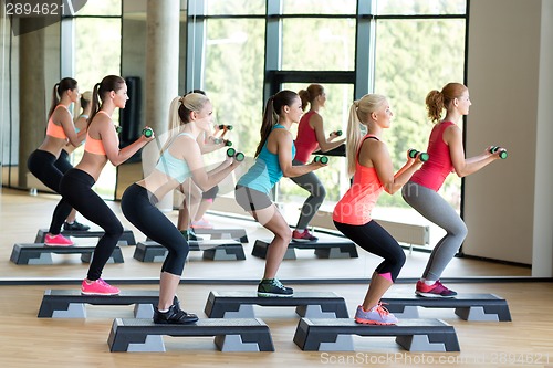 Image of group of women with dumbbells and steppers