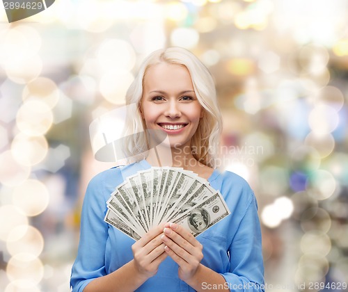 Image of smiling young woman with us dollar money