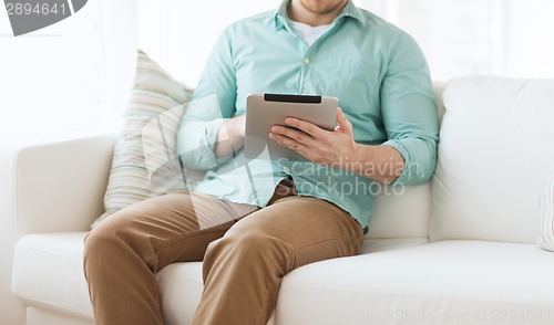 Image of close up of man with tablet pc computer at home