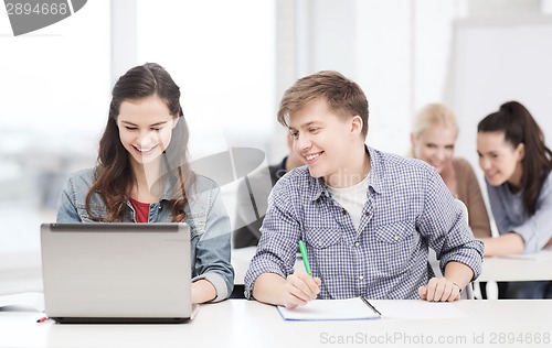 Image of students with laptop and notebooks at school