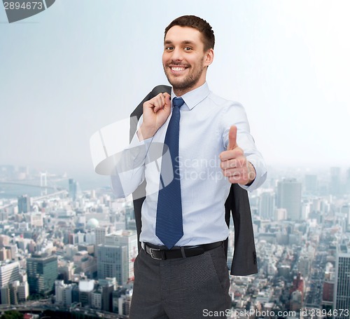 Image of smiling young businessman showing thumbs up
