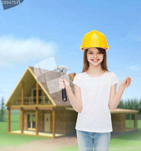 Image of smiling little girl in hardhat with hammer