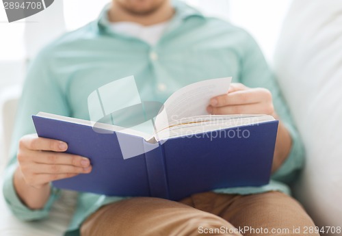 Image of close up of man reading book at home