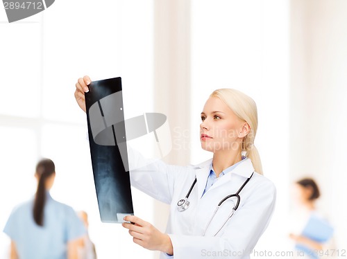 Image of serious female doctor looking at x-ray