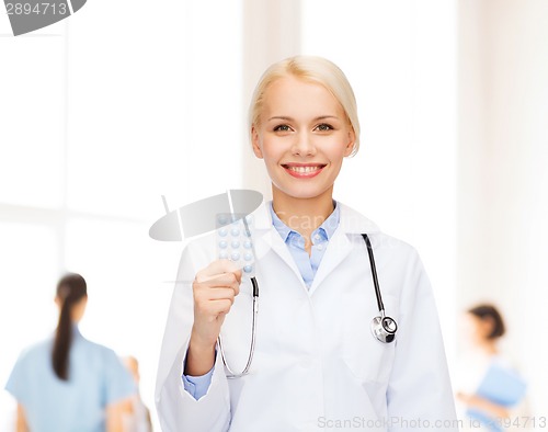 Image of smiling female doctor with pills