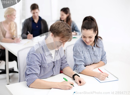 Image of smiling students with notebooks at school