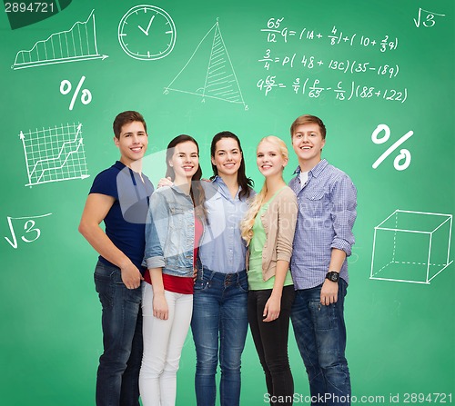 Image of group of smiling students over green board