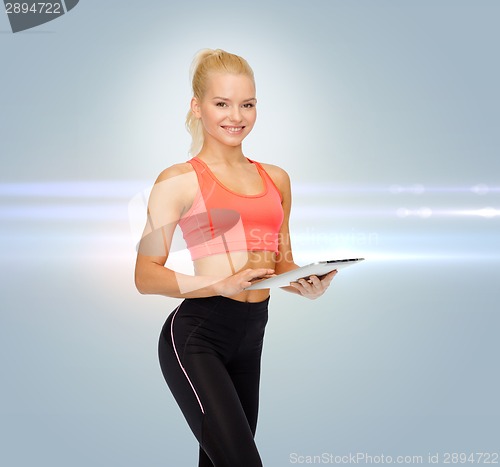 Image of smiling sporty woman with tablet pc computer