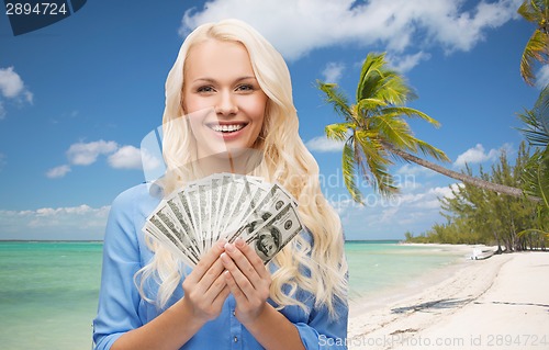 Image of smiling young woman with us dollar money