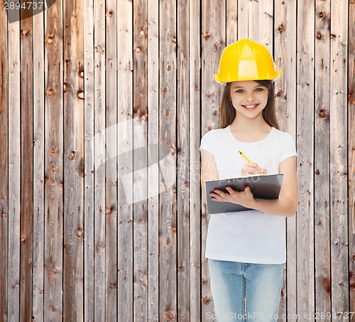 Image of smiling little girl in hardhat with clipboard