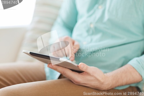 Image of close up of man with tablet pc computer at home