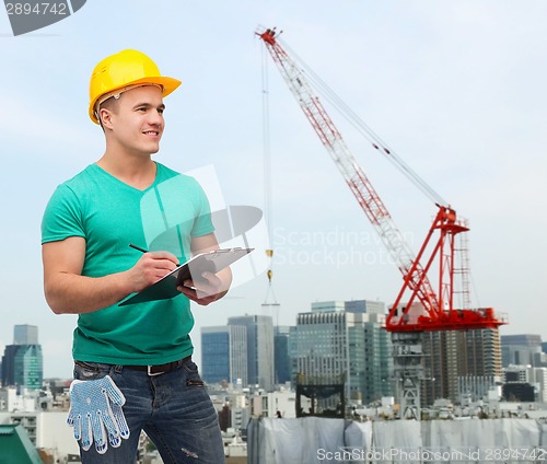 Image of smiling man in helmet with clipboard