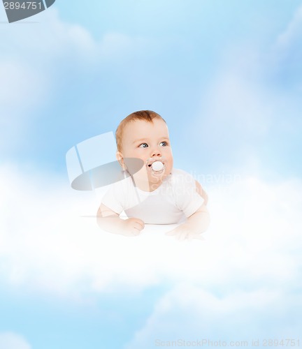 Image of smiling baby lying on cloud with dummy in mouth