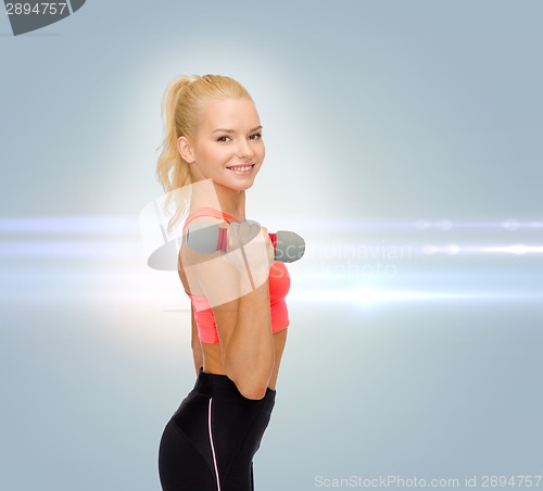 Image of smiling beautiful sporty woman with dumbbell