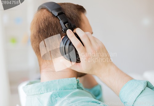 Image of close up of man in headphones at home