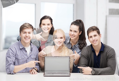 Image of smiling students pointing to blank lapotop screen