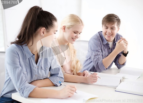 Image of smiling students with notebooks at school