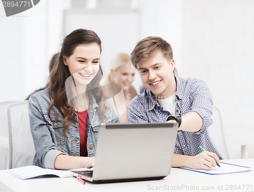 Image of students with laptop and notebooks at school