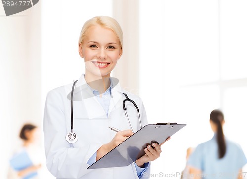 Image of smiling female doctor with clipboard