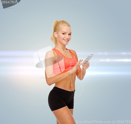 Image of smiling sporty woman with smartphone and earphones
