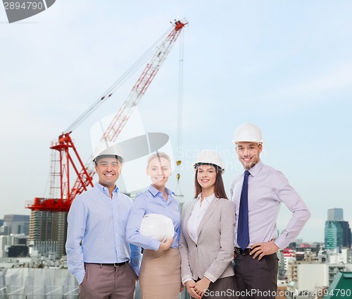 Image of group of smiling businessmen in white helmets