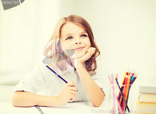 Image of girl drawing with pencils at school