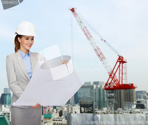 Image of businesswoman in white helmet with blueprint