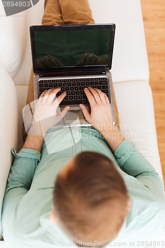 Image of close up of man working with laptop at home