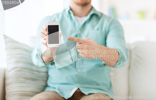 Image of close up of man sitting with smartphone at home