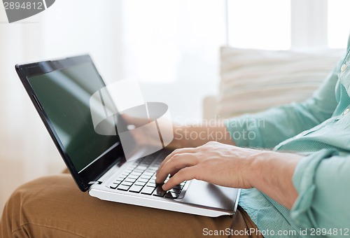 Image of close up of man working with laptop at home