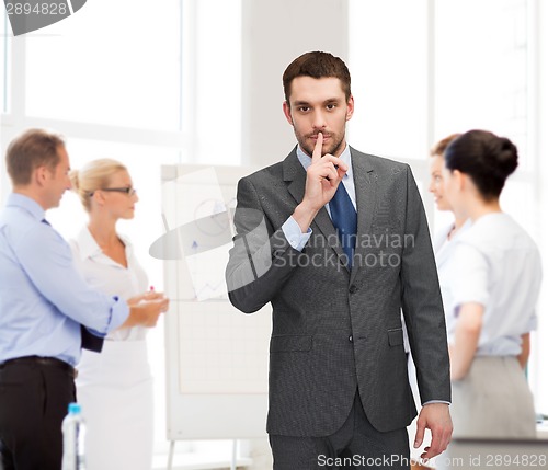 Image of group of businessmen making hush sign