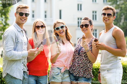 Image of group of smiling friends with ice cream outdoors