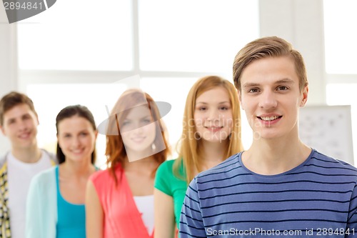 Image of smiling students with teenage boy in front