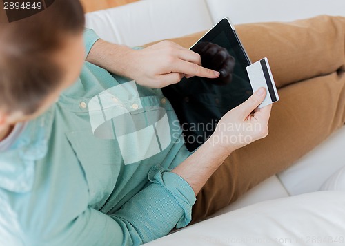 Image of close up of man with laptop and credit card