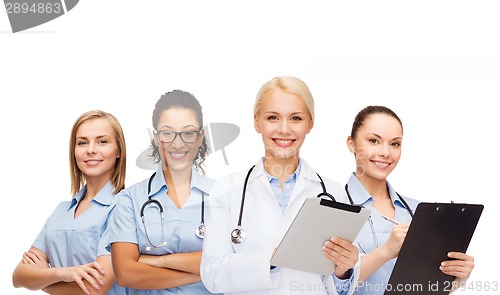 Image of smiling female doctor and nurses with tablet pc