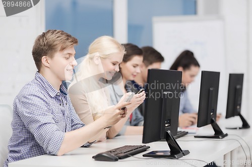 Image of students with computer monitor and smartphones