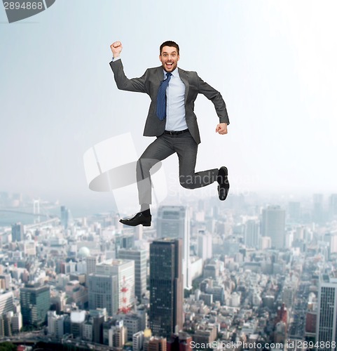 Image of smiling happy businessman jumping