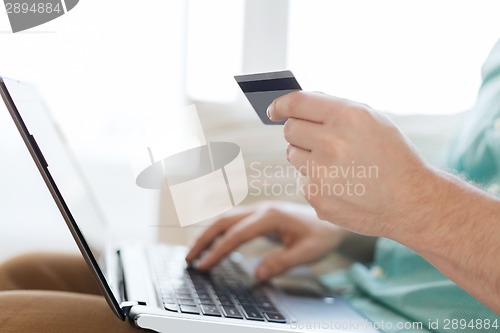 Image of close up of man with laptop and credit card