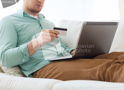 Image of close up of man with laptop and credit card