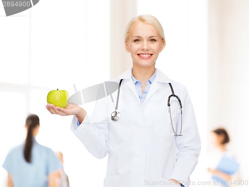 Image of smiling female doctor with green apple