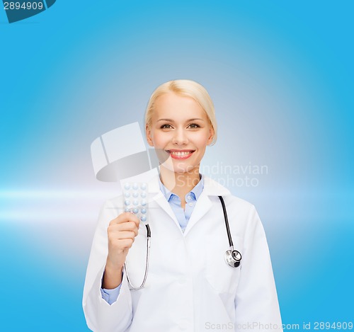 Image of smiling female doctor with pills