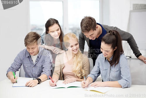 Image of smiling students with notebooks at school