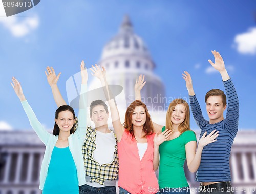 Image of group of smiling students waving hands