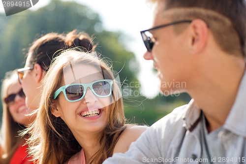 Image of group of smiling friends sitting on city street